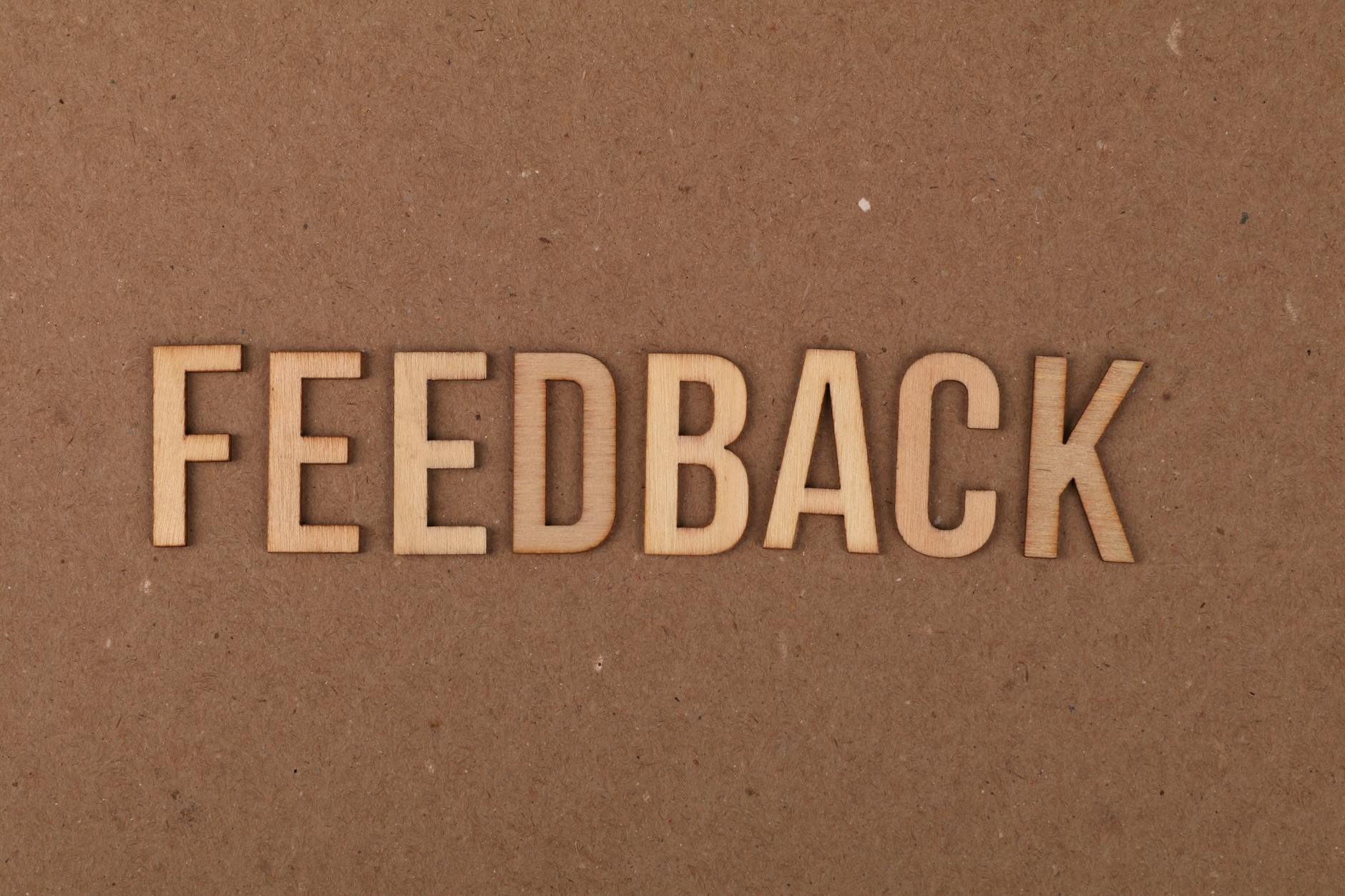 Wooden FEEDBACK sign on cardboard texture